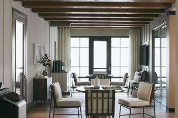 a living room with a table and chairs and a large window at Livano Avondale, Avondale